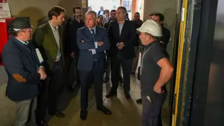 Políticos visitando la obra de un ascensor.