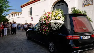 Coche con coronas de flores camino del cementerio de Gerena.