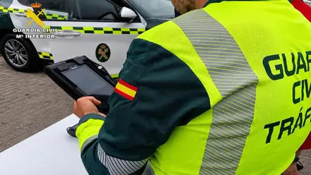 Agente de la Guardia Civil de Tráfico multando a un condcutor infractor.