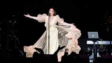Con un traje blanco Isabel Pantoja en el escenario.
