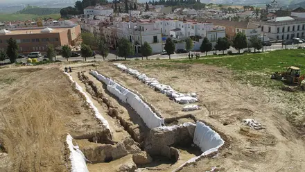 Vista del dolmen de Montelirio junto a construcciones y edificaciones modernas.