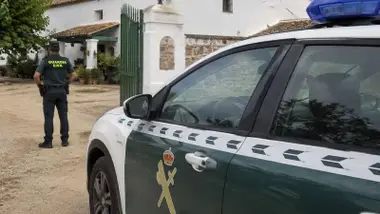Agente y vehículo de la Guardia Civil en un cortijo.