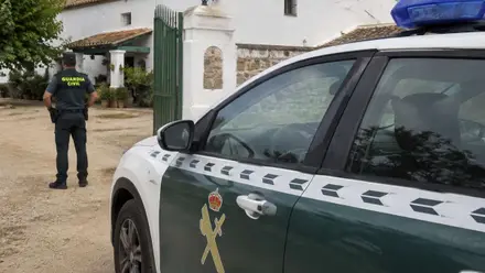 Agente y vehículo de la Guardia Civil en un cortijo.
