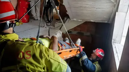 Camilla y herido sacado por los bomberos.