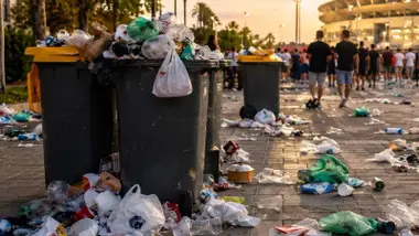 Papeleras y cubos de basura saturados tras un concierto.
