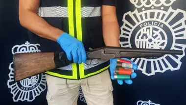 Agente de la Policía Nacional sostiene en sus manos el arma.
