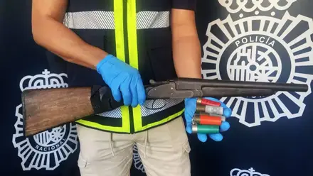 Agente de la Policía Nacional sostiene en sus manos el arma.