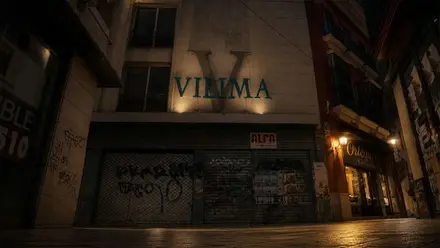 Fotografía nocturna de Vilima, el cartel iluminado por dos focos.