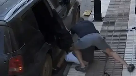 Junto a un coche un agente de la Guardia Civil fuera de servicio reduce al sospechoso.