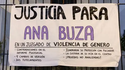 Una pancarta con letras moradas y negras pidiendo justicia para Ana Buza.