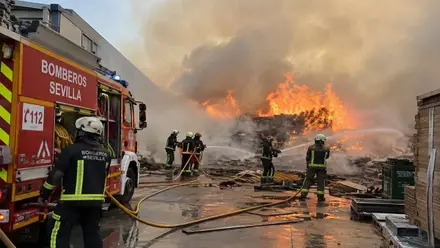 Bomberos apagando el incendio de la nave.