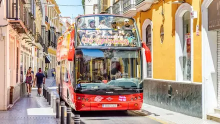 Autobús rojo de turistas en un tour por Sevilla.