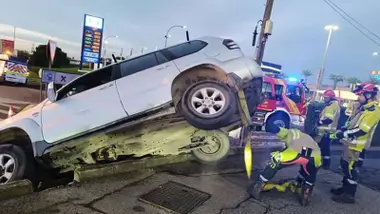 Coche 4x4 blanco siendo asegurado por los bomberos.