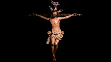 Cristo de la Exaltación destacando sobre fondo negro.