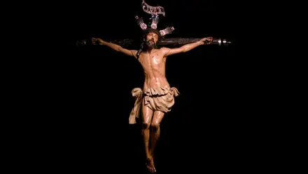 Cristo de la Exaltación destacando sobre fondo negro.