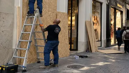 Trabajadores protegiendo escaparates.