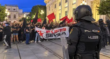 Manifestantes portando una pancarta y la Policía Nacional.