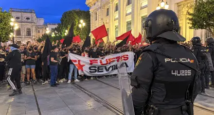 Manifestantes portando una pancarta y la Policía Nacional.